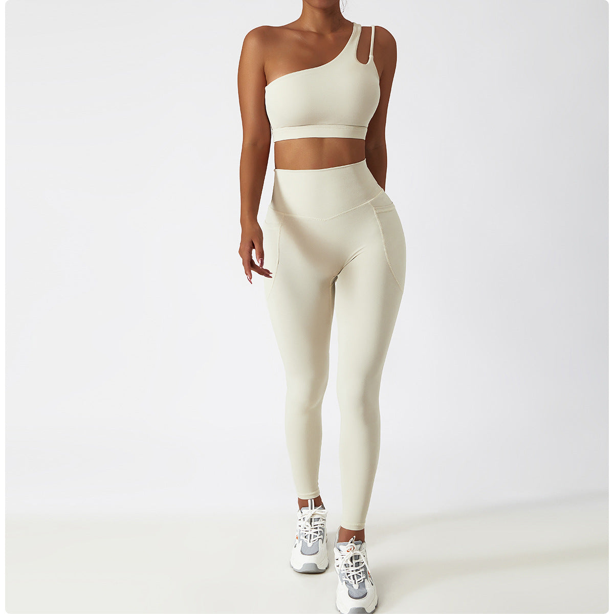 Cream-colored one-shoulder sports bra and high-waisted leggings set for stylish workouts