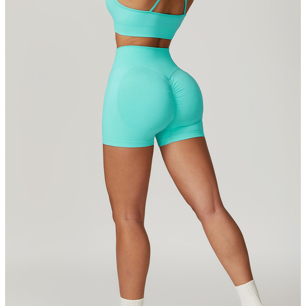 Woman in turquoise seamless yoga suit, featuring Bra Shorts Rhino design