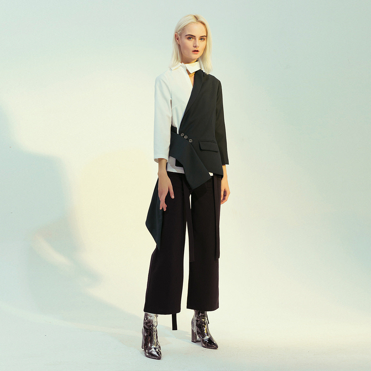 Woman in a two-tone blazer and black pants showcasing modern fashion ملابس style