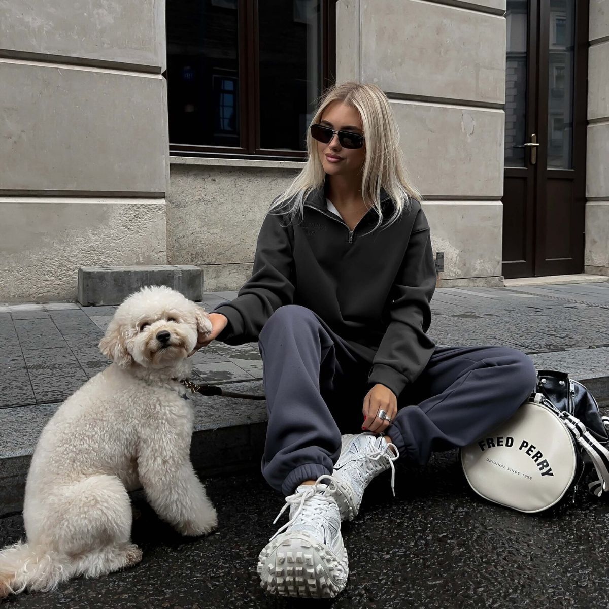 Woman in a gray tracksuit with a white dog promoting Langry fashion ملابس in casual style