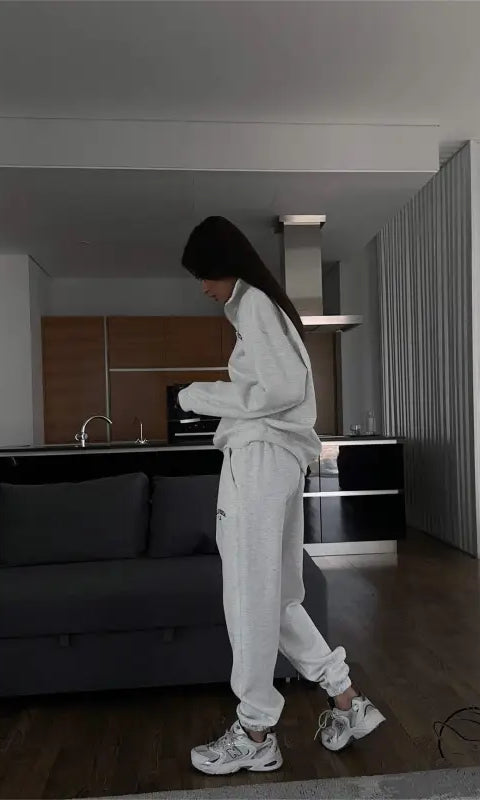Woman in white tracksuit wearing autumn winter fleece lined half zipper sweater