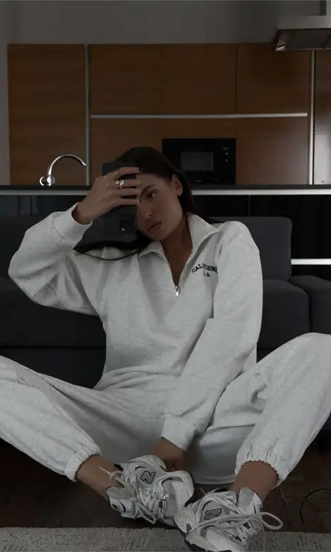 Woman in white tracksuit with autumn winter fleece lined half zipper sweater