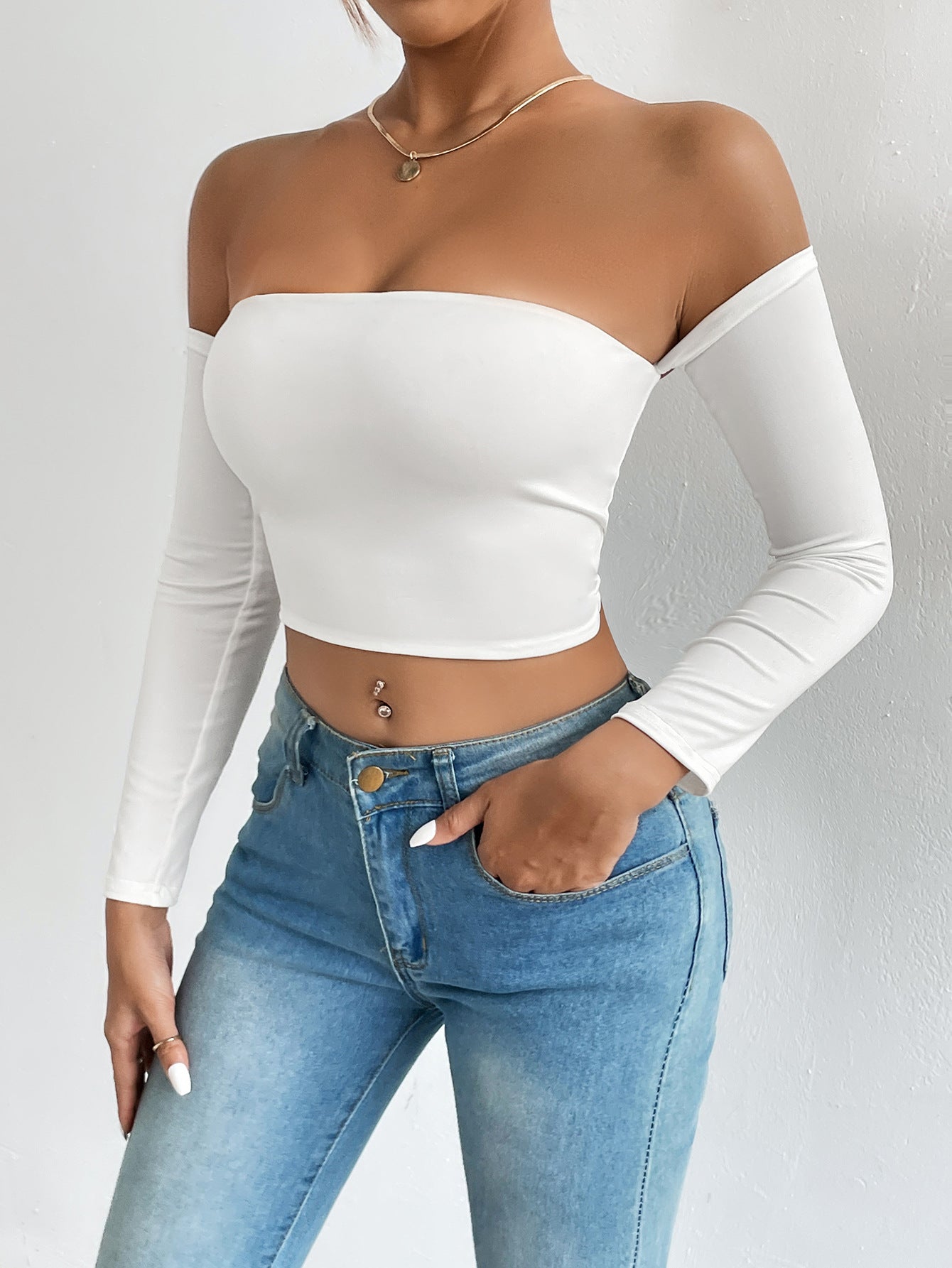 White off-the-shoulder long-sleeve crop top with light wash denim jeans, stylish ملابس for fashion