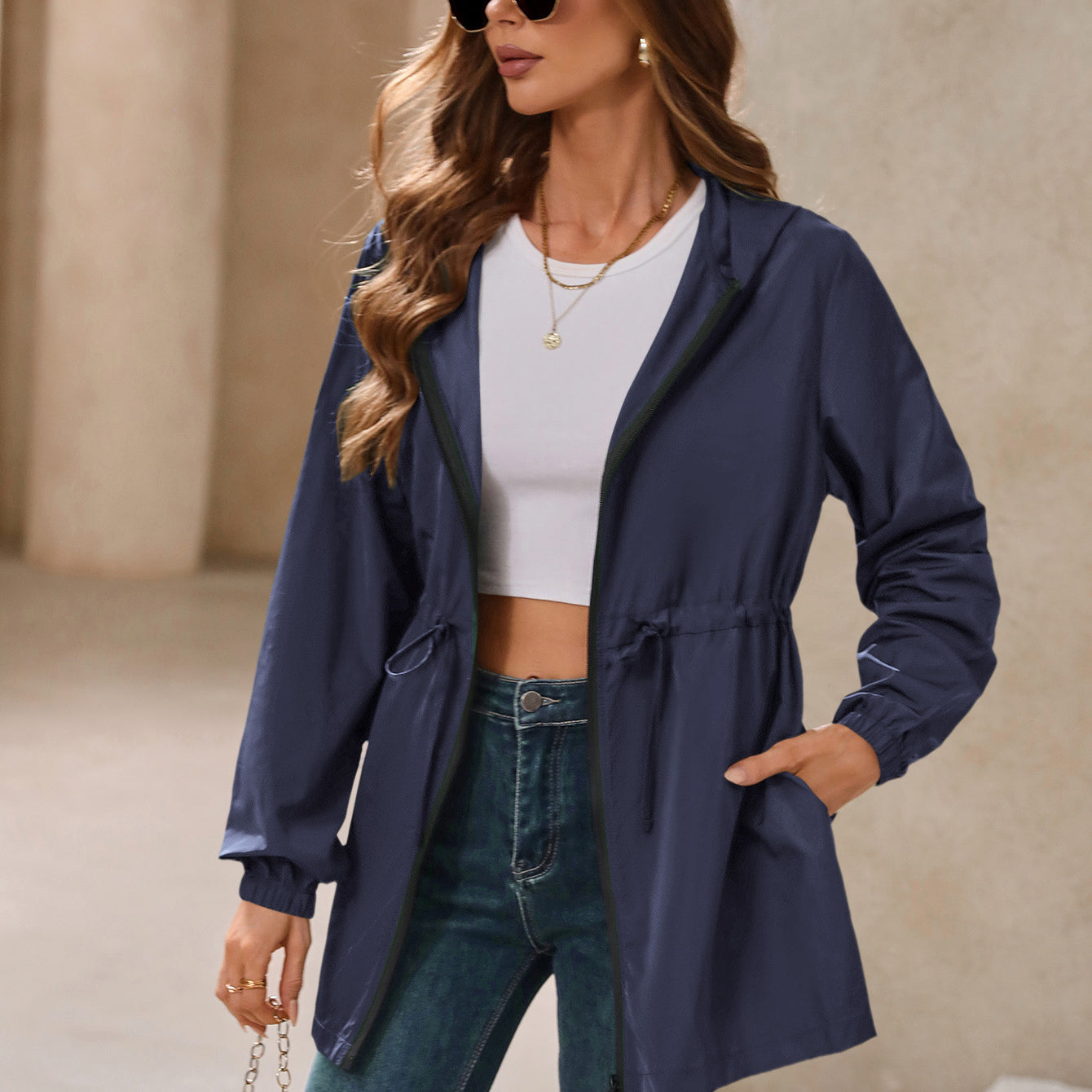 Woman wearing navy hooded outdoor raincoat, waterproof windcheater jacket for outdoor activities