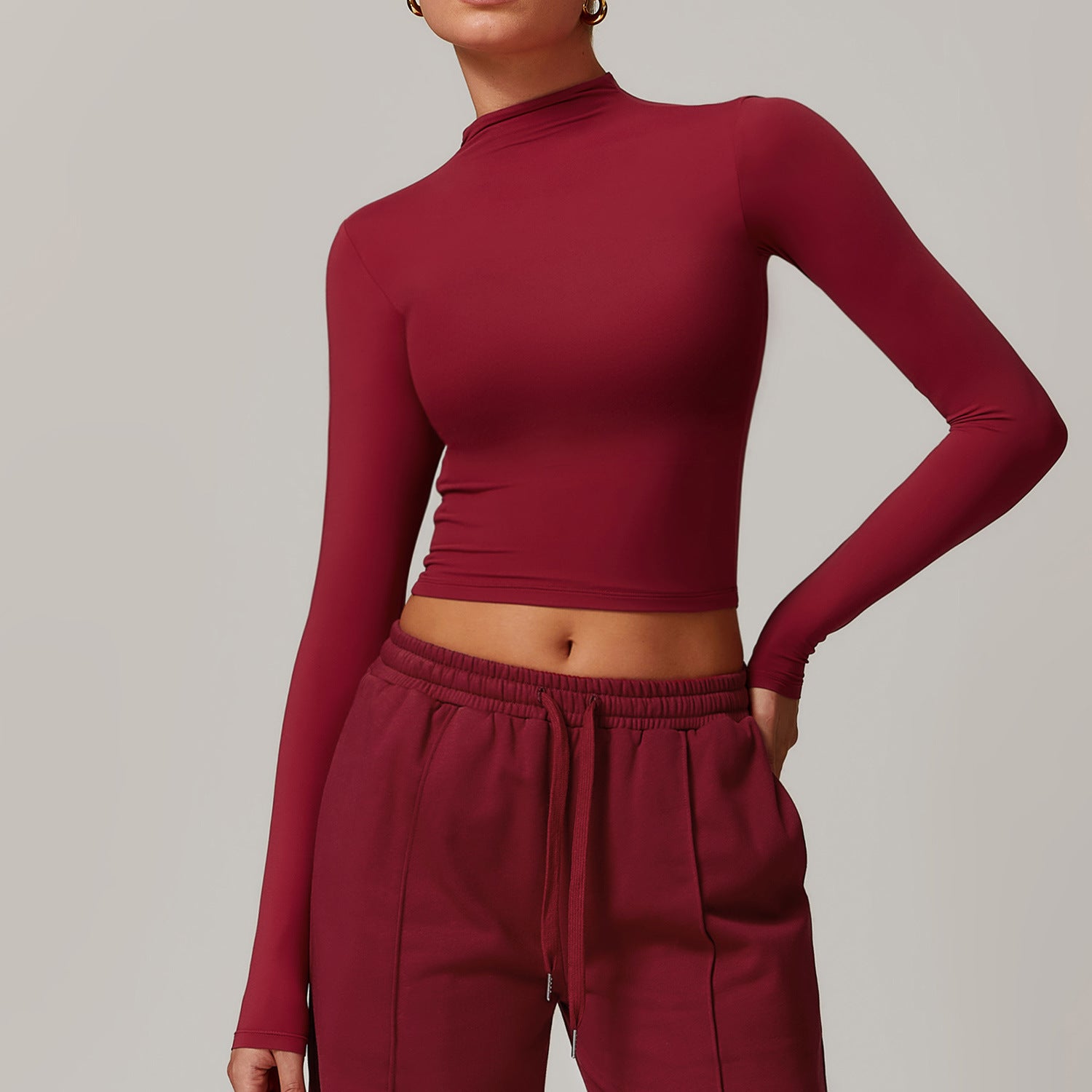 Burgundy long-sleeved crop top with mock neckline for fashionable fitness ملابس