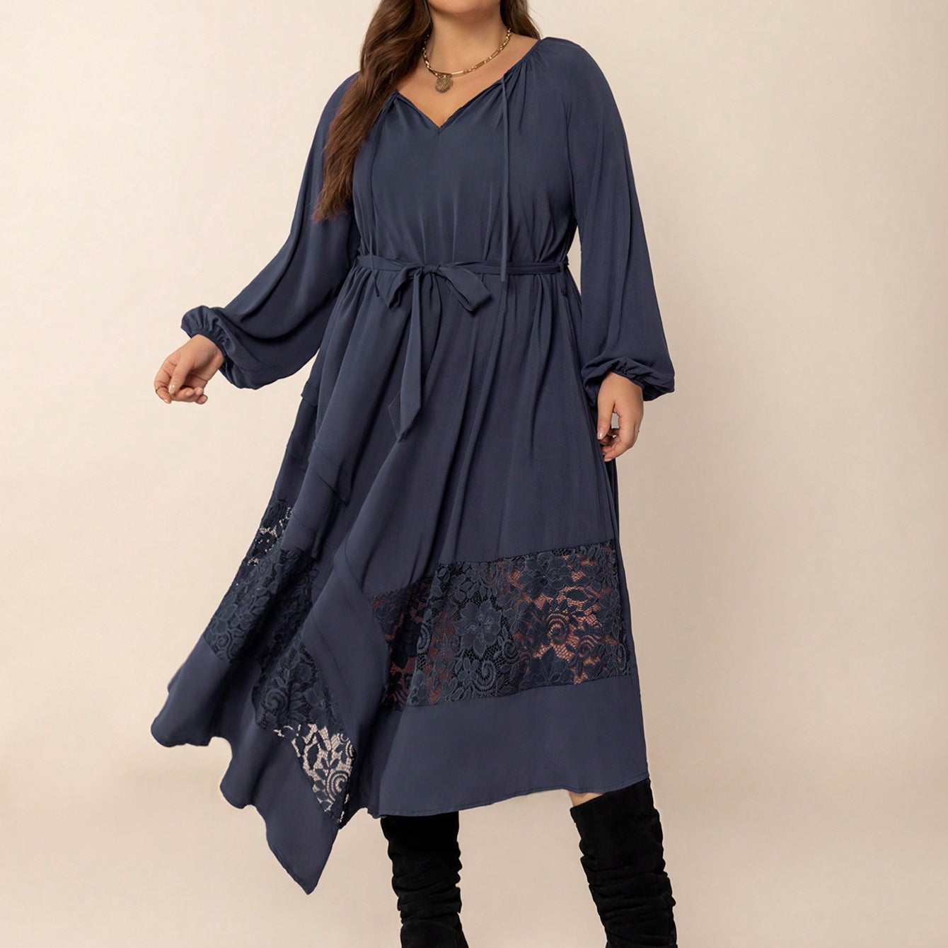 Plus-size woman wearing a dark blue winter cozy dress with lace panels and tie waist