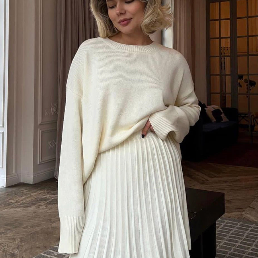 Woman in a white sweater and pleated knitted skirt from Cute Knitted Skirt Sets