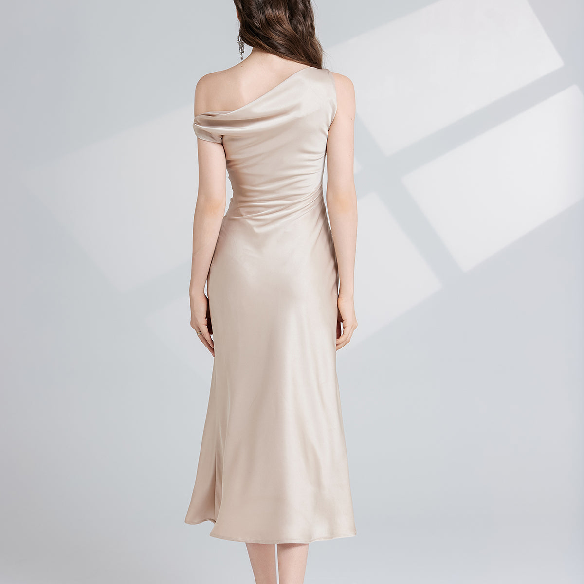 Elegant champagne-colored one-shoulder maxi dress showcasing sophisticated fashion style