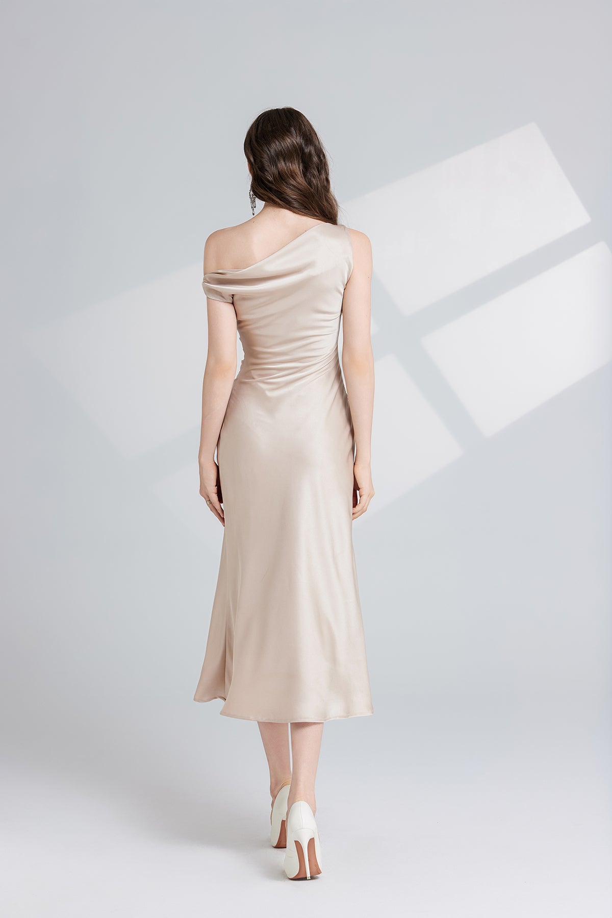 Elegant champagne-colored one-shoulder maxi dress showcasing sophisticated fashion style