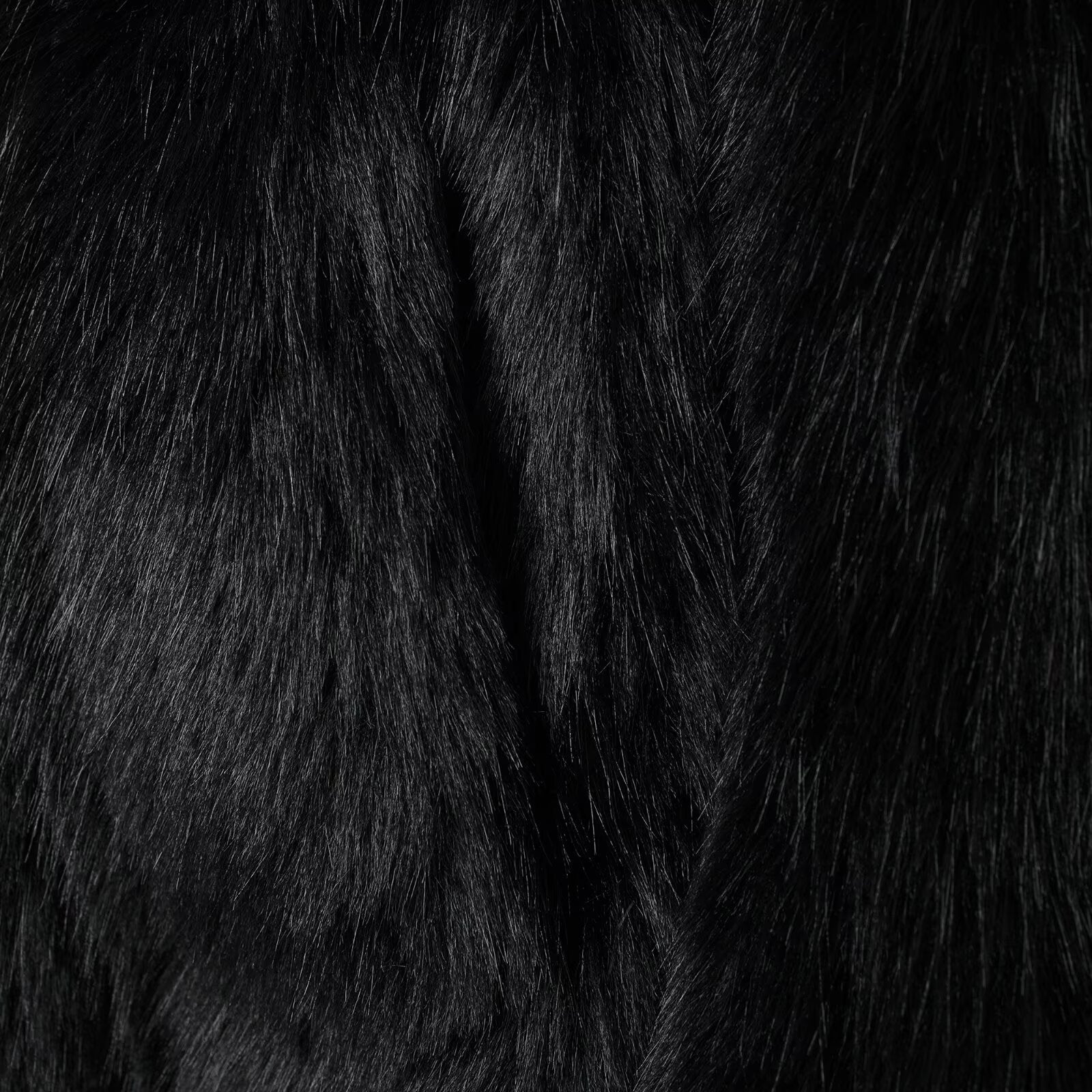 Black faux fur fabric with a luxurious shaggy texture for fashionable warmth