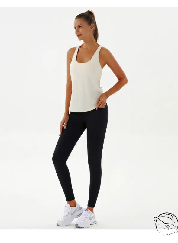 Woman in cream tank top and black leggings, yoga breathable fashion