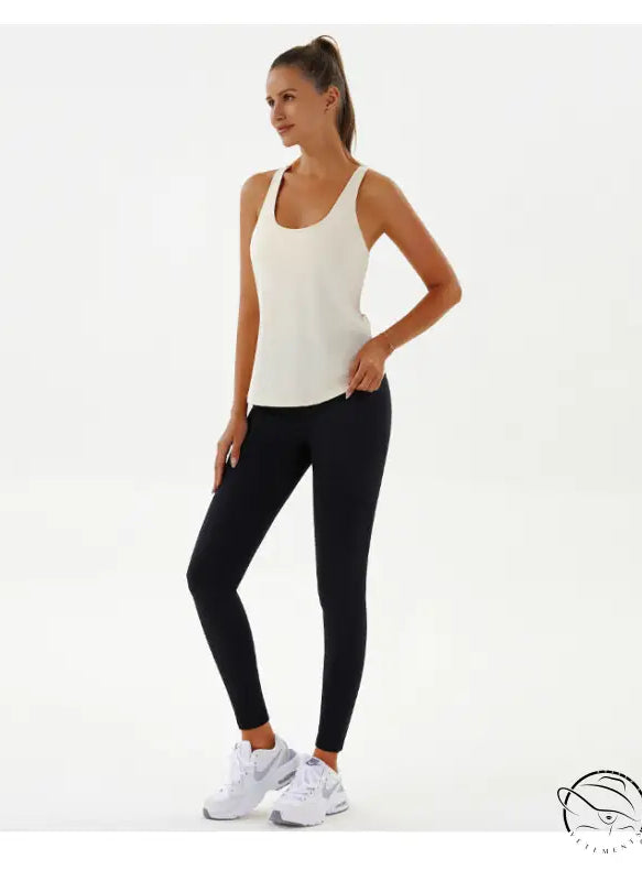 Woman in cream tank top and black leggings, yoga breathable fashion