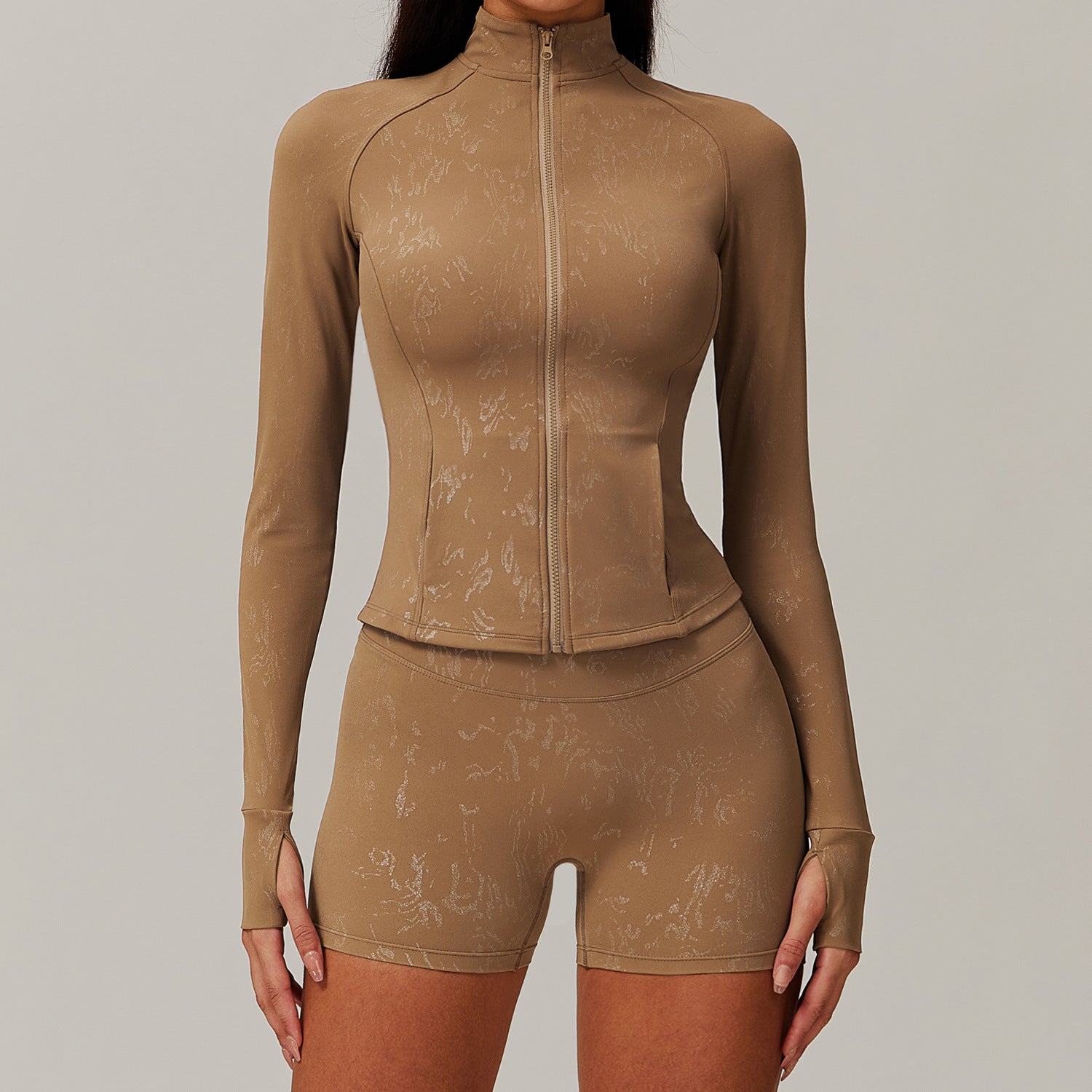 Woman modeling tan matching long-sleeve zip-up top and biker shorts in langry fashion