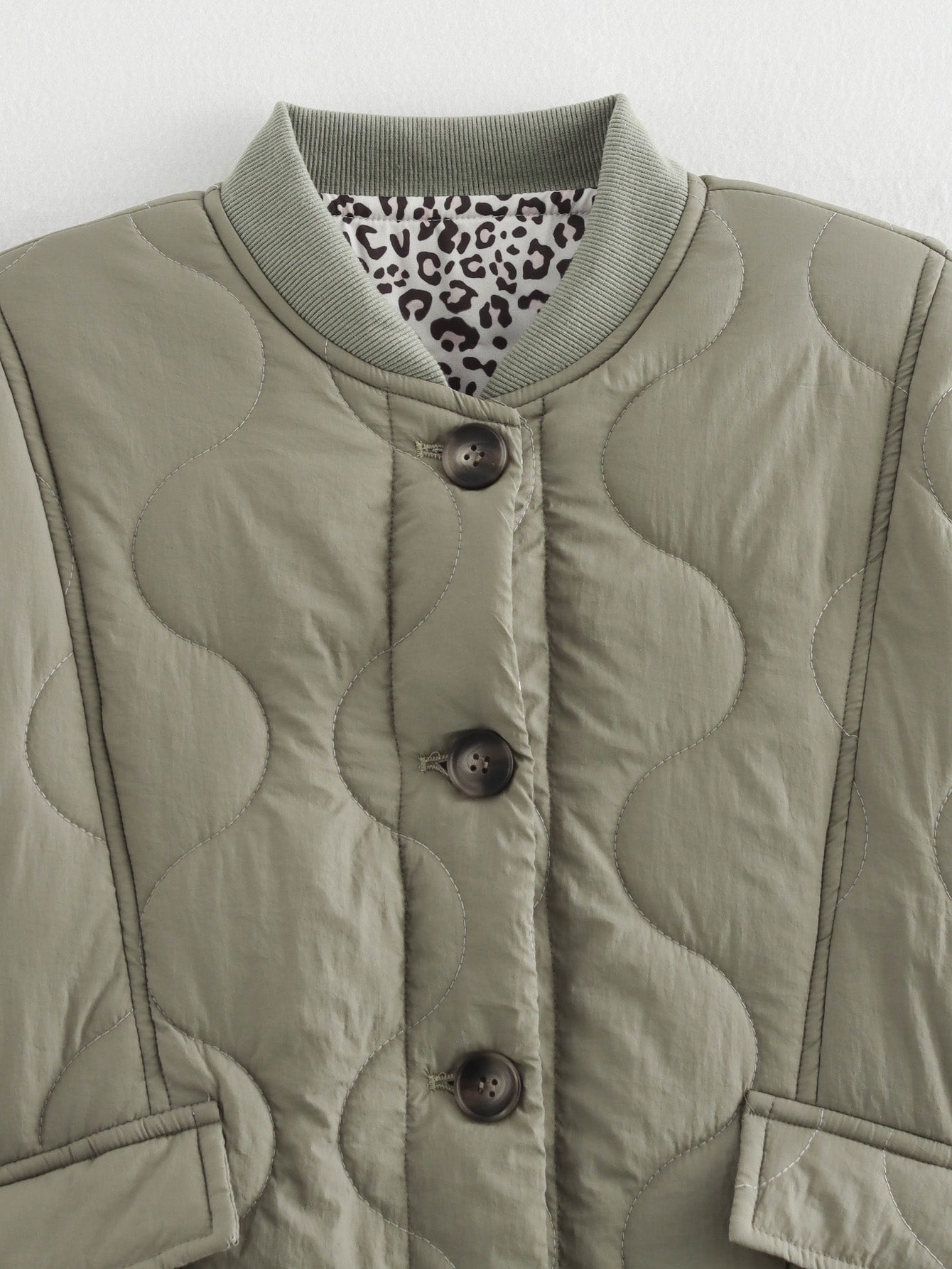 Quilted olive jacket with animal print lining, a stylish addition to any fashion wardrobe