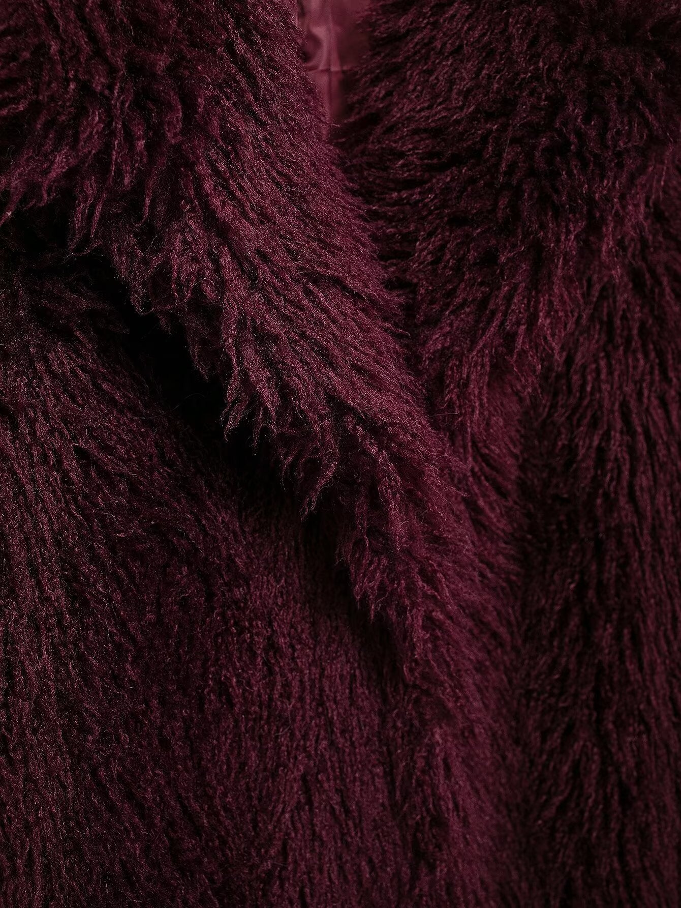 Close-up of a burgundy faux fur garment with shaggy texture from the Faux Fur Effect Mid Length Coat collection
