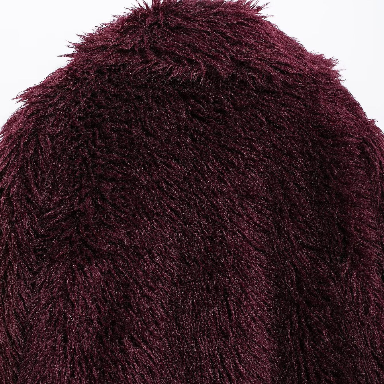 Close-up of maroon faux fur effect mid-length coat showcasing shaggy fashion style