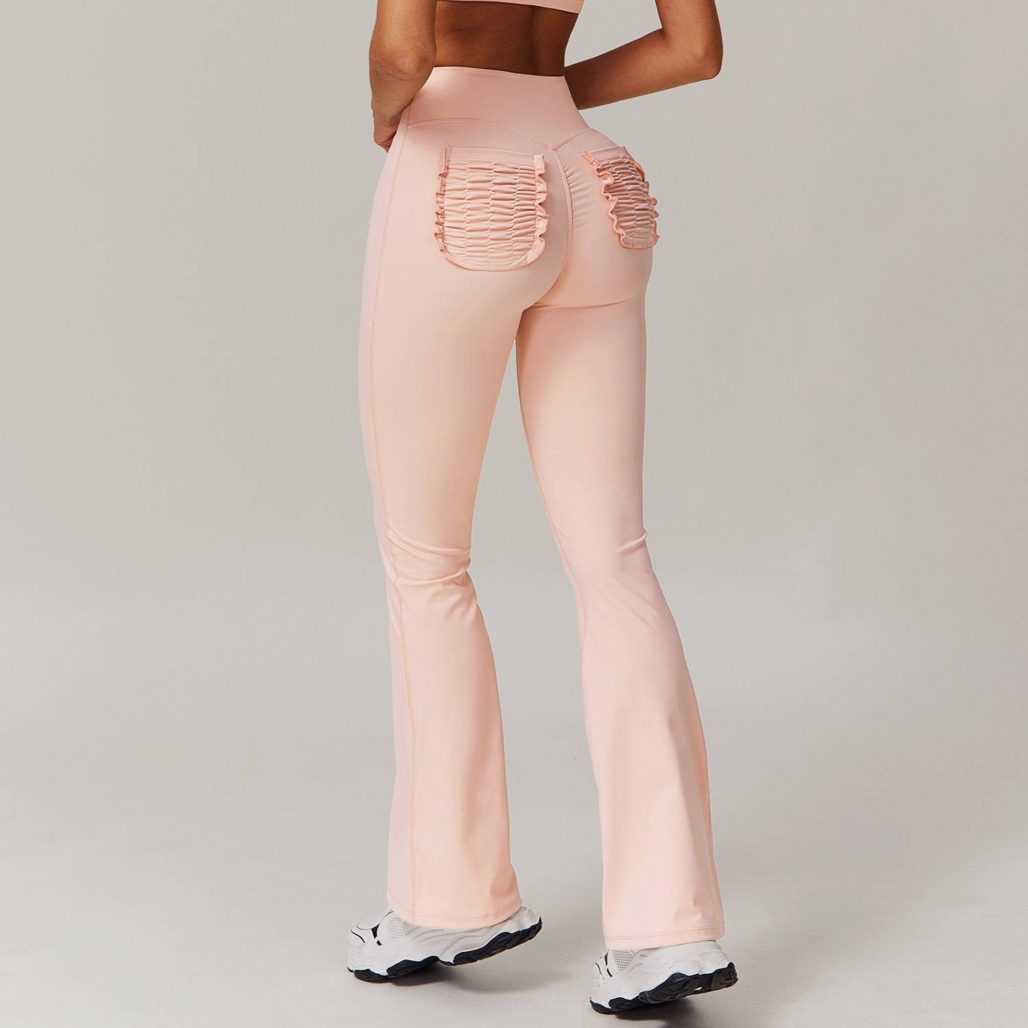 Peach-colored flared leggings with ruched back pockets in fashionable langry style
