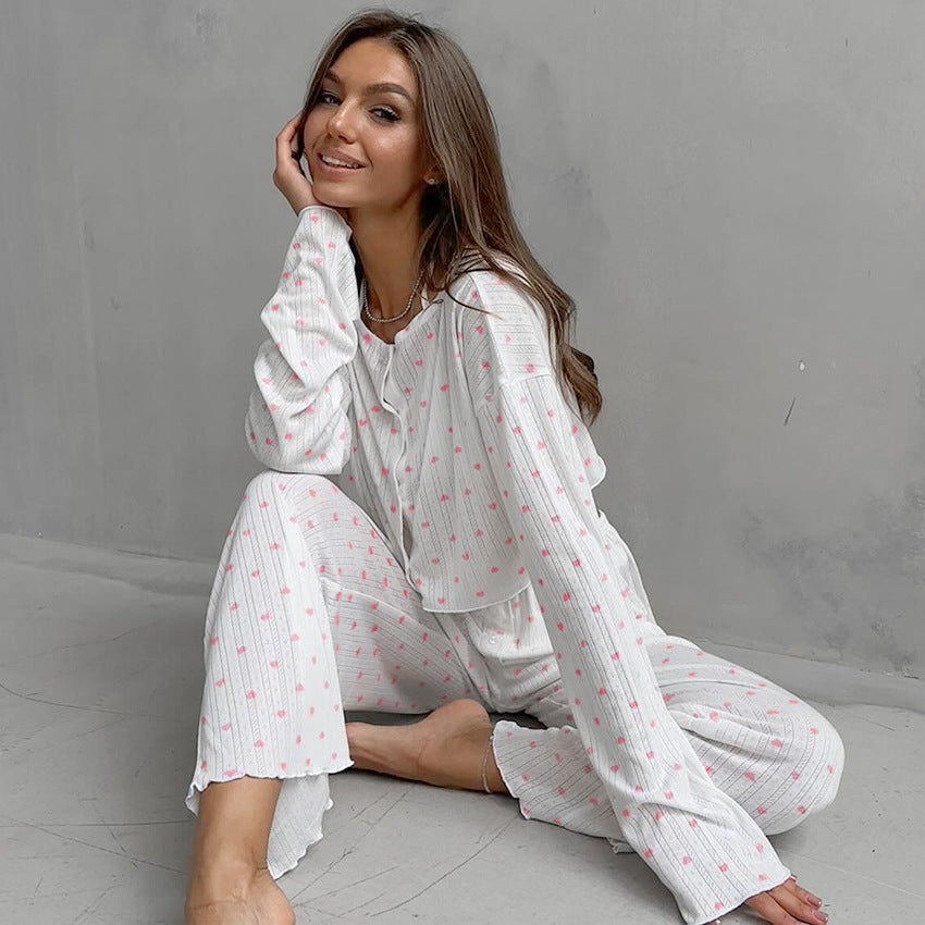 Woman in white knitted heart printing pajamas with small pink hearts for comfortable sleep