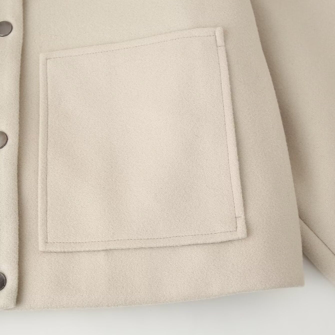 Cream-colored pocket detail with perforated buttons on Langry single breasted jacket