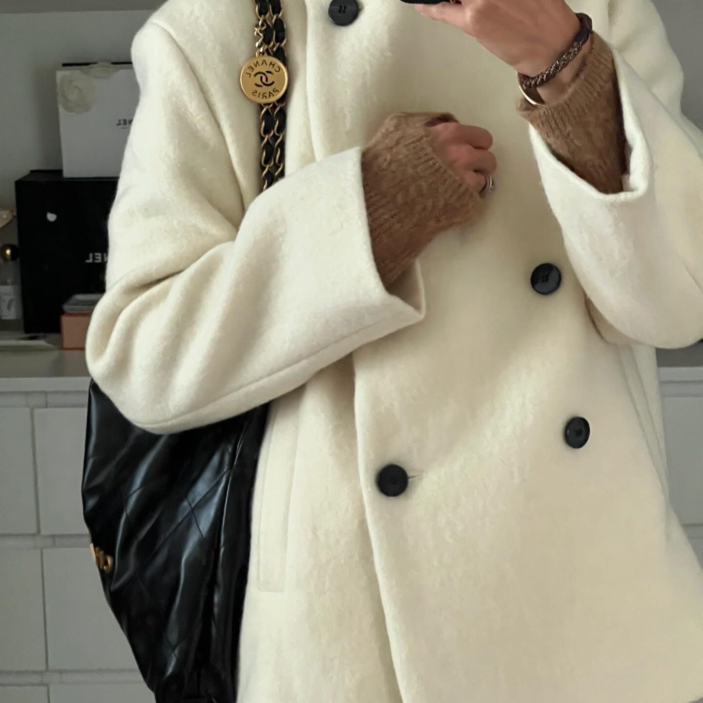 Cozy thickened hem langry fashion woolen coat with cream double-breasted design, black buttons, and chain strap