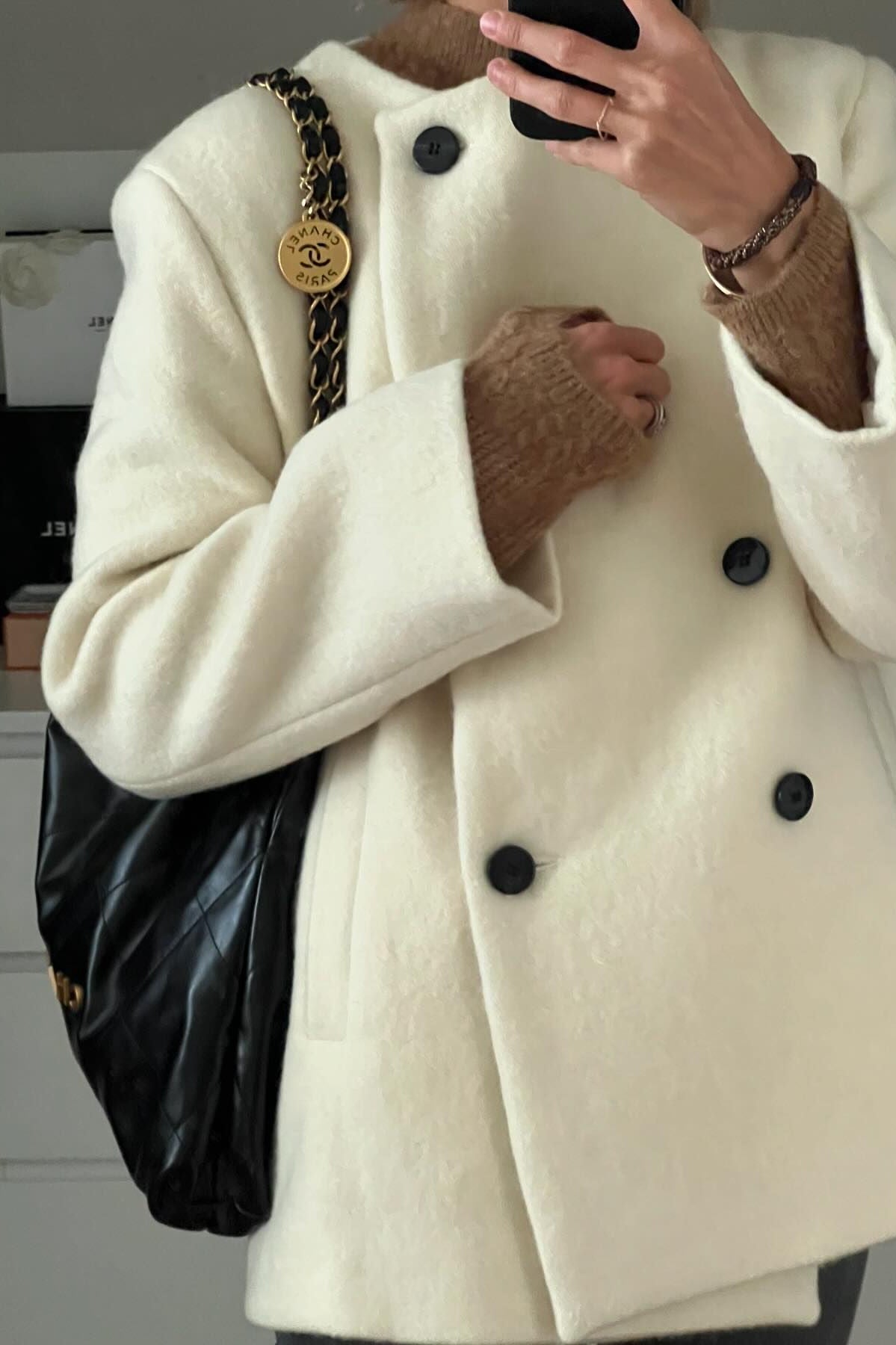 Cozy thickened hem langry fashion woolen coat with cream double-breasted design, black buttons, and chain strap