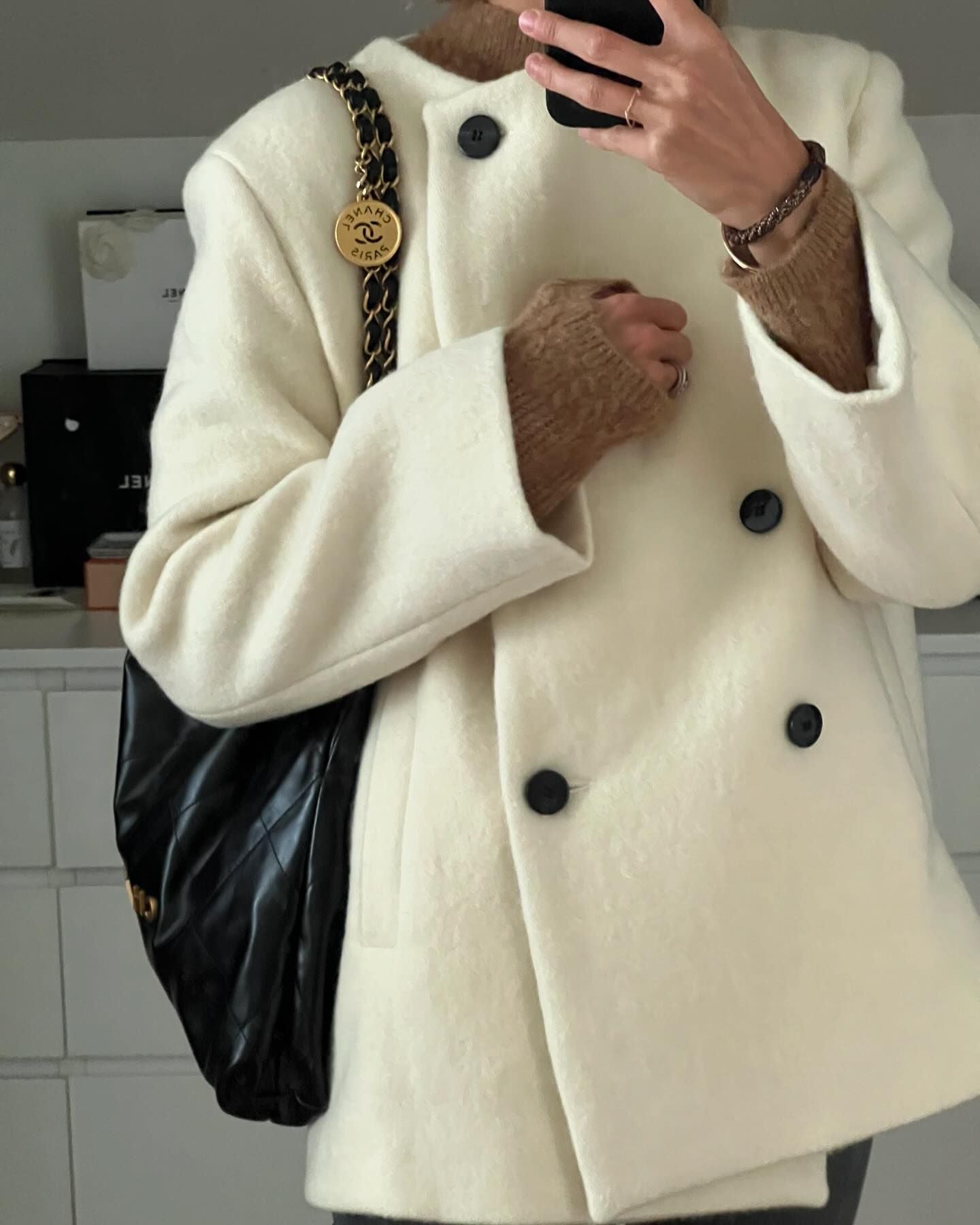 Cozy thickened hem langry fashion woolen coat with cream double-breasted design, black buttons, and chain strap