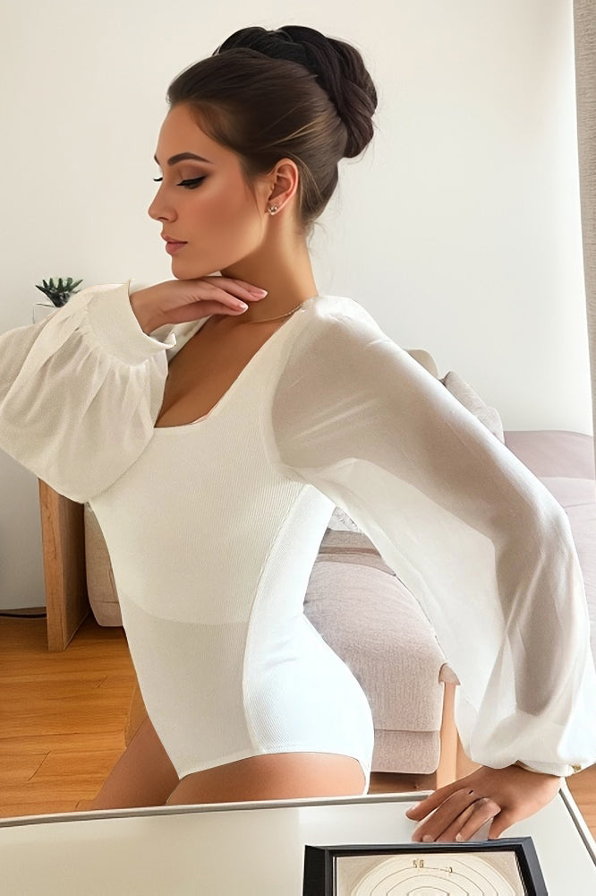 White bodysuit featuring dramatic lantern sleeves and a fitted silhouette for elegant fashion