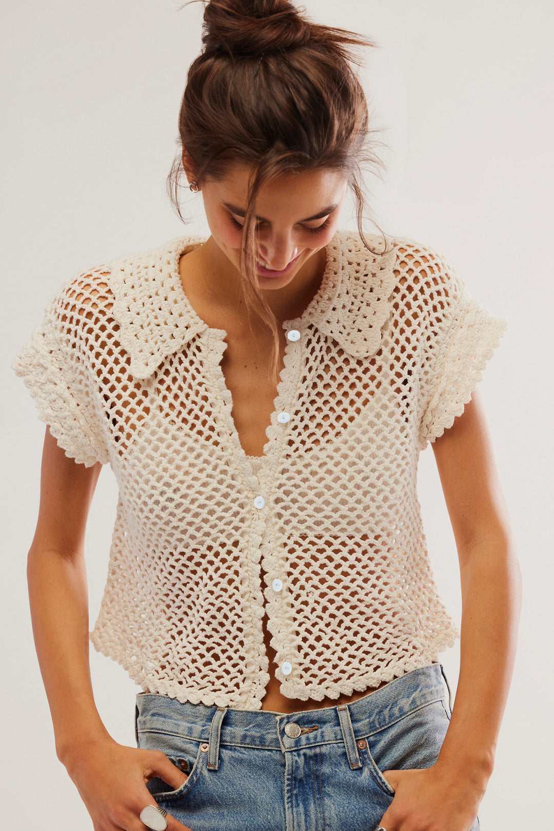 Cream-colored crochet button-up top styled with blue jeans for fashionable langry ملابس