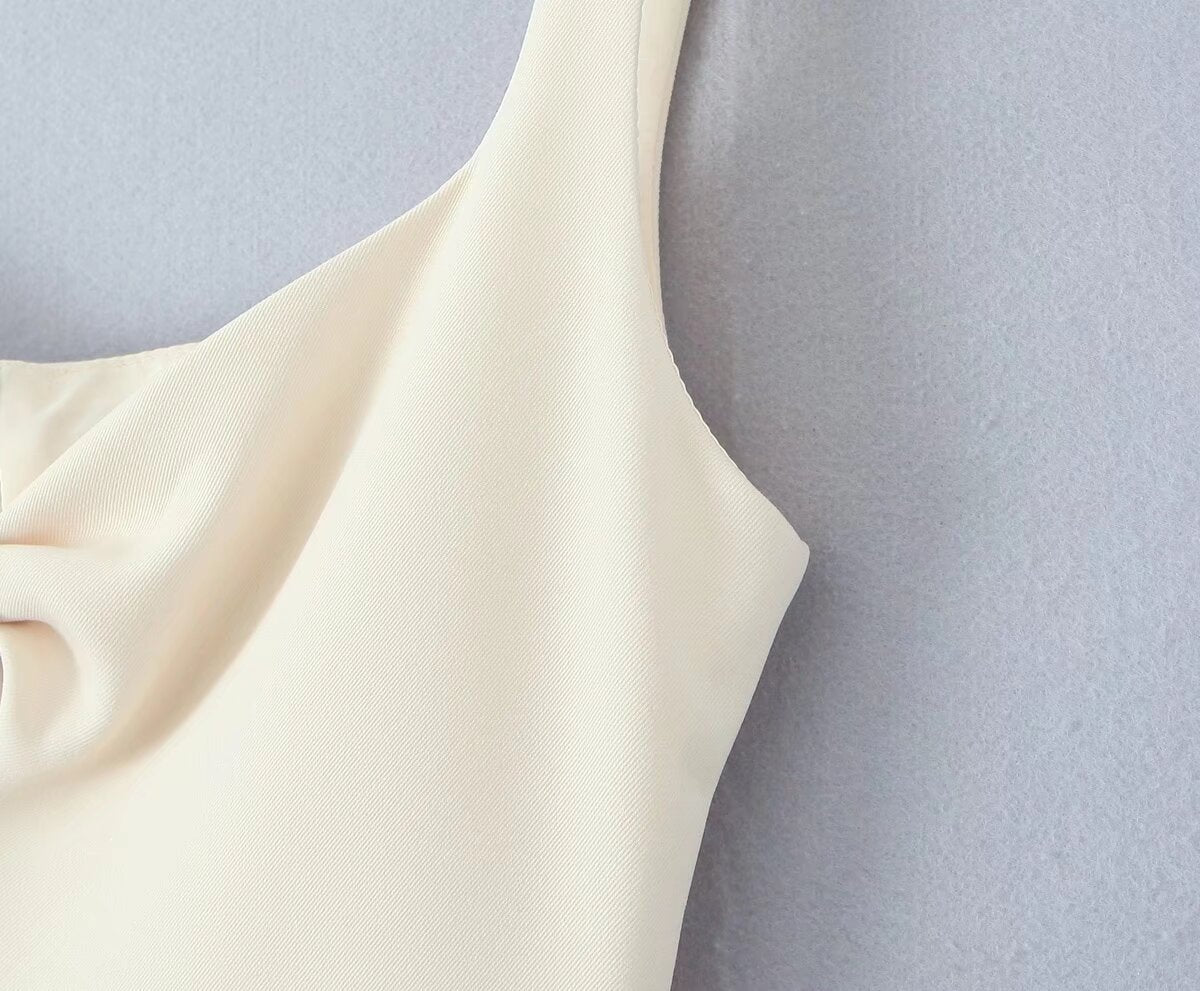 Cream-colored sleeveless garment with curved neckline from the Stunning Retro Backless Dress