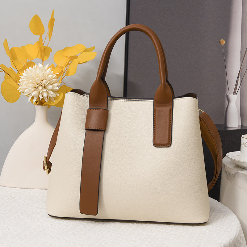 Cream-colored handbag with brown leather trim, perfect for fashion and ملابس enthusiasts
