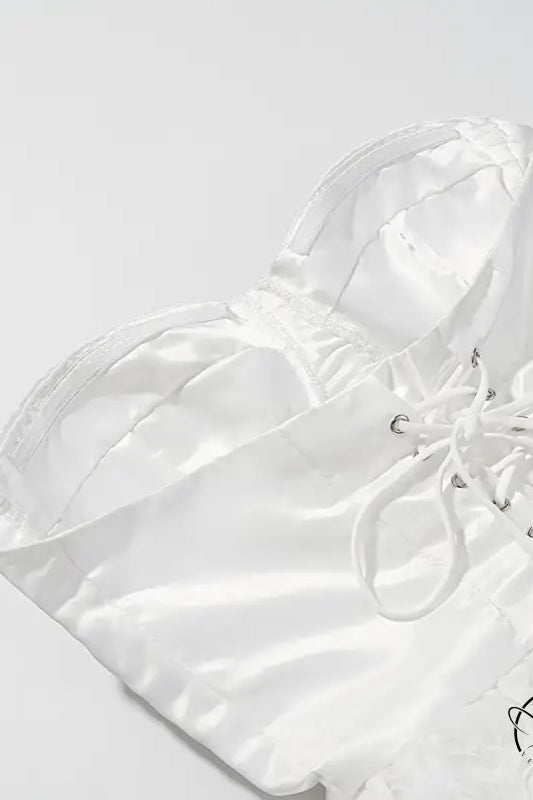 White satin lace-up shoe with silver accents, bow, and early spring floral design