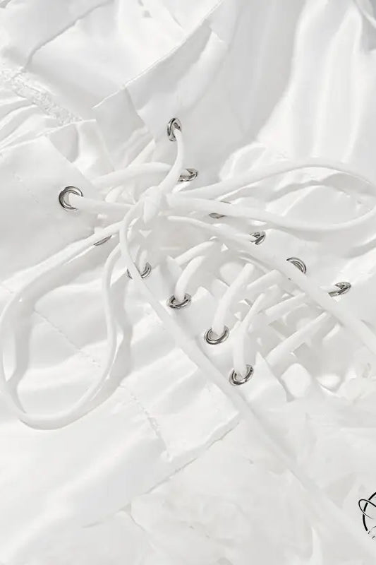 White lace-up boot with silver eyelets on early spring floral dress