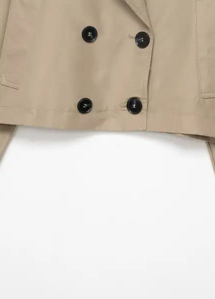 Beige double breasted short trench coat with black buttons and pockets