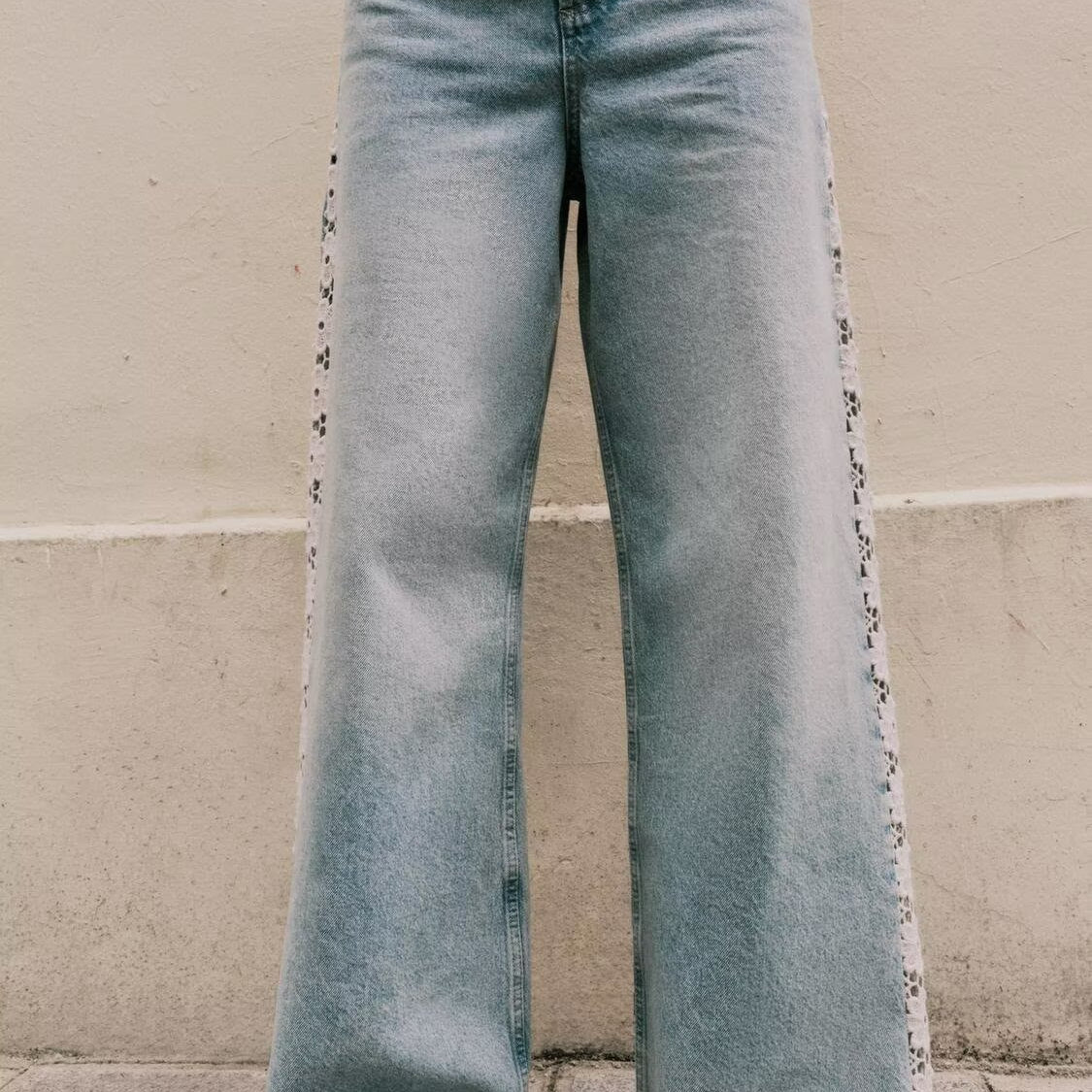 High-waisted light blue wide leg jeans with crochet stitching