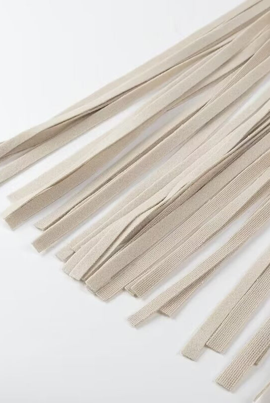 Beige woven cord tassel necklace with silver accents on Langry fashion trench coat