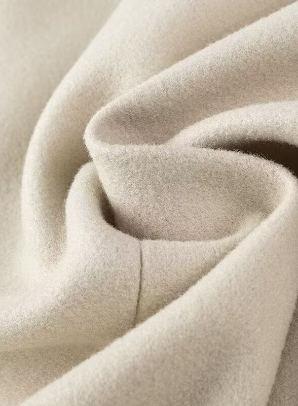 Cozy cream-colored plush blanket with soft folds in Langry fashion trench coat