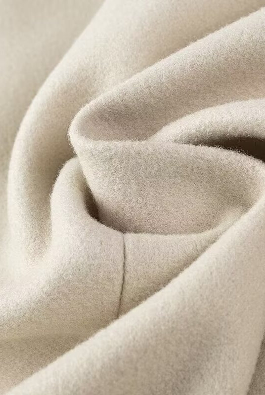Cozy cream-colored plush blanket with soft folds in Langry fashion trench coat