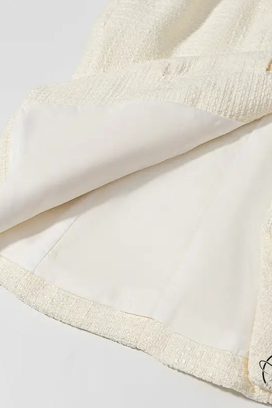 Cream-colored bath towel with textured border and pom-poms for enchanting short sleeve bud top suit