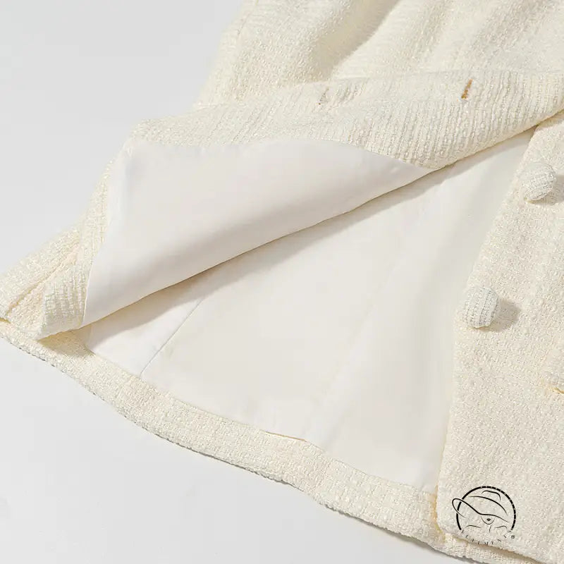 Cream-colored bath towel with textured border and pom-poms for enchanting short sleeve bud top suit