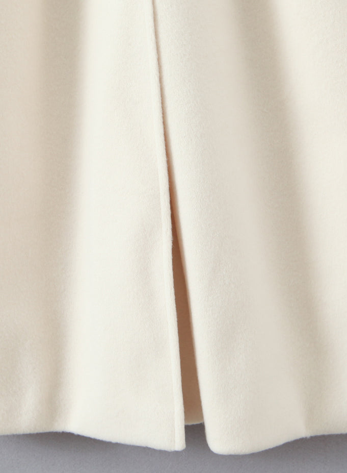 Elegant white woolen langry fashion coat with cream-colored pleated skirt slit