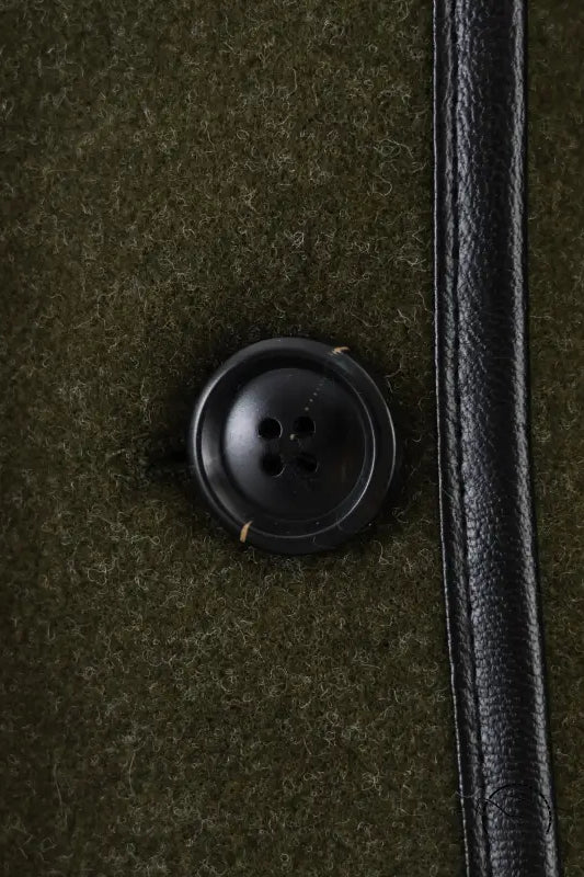 Black button with four holes on textured fabric for Langry fashion woolen coat