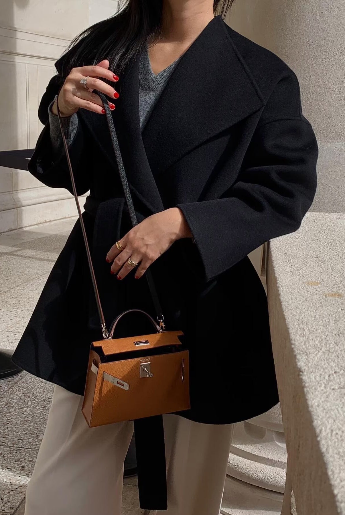 Langry fashion black leather crossbody bag with gold hardware and orange interior for elegant woolen coat