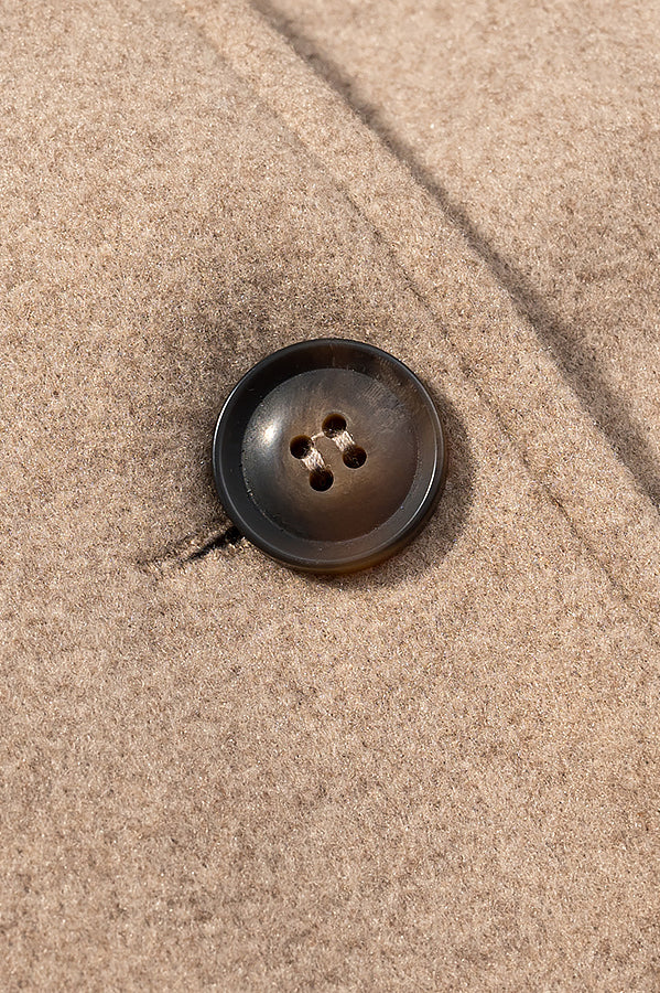 Elegant langry autumn woolen coat with brown four-hole button on beige fabric