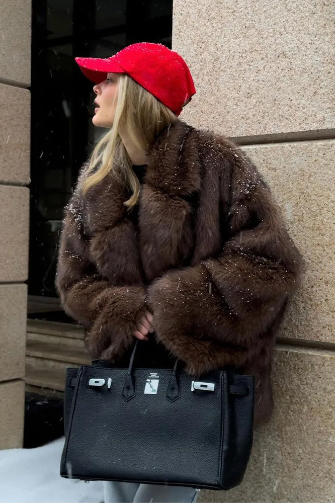 Fashionable faux fur coat with black leather Hermès Birkin handbag and silver hardware