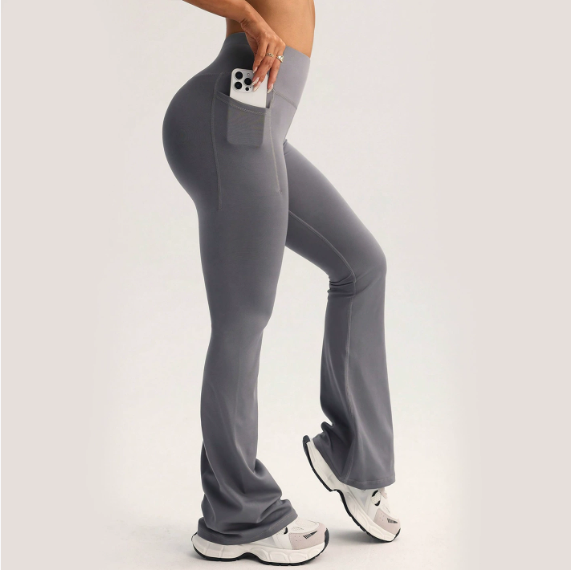 Gray high-waisted flared langry yoga pants with side pocket holding smartphone