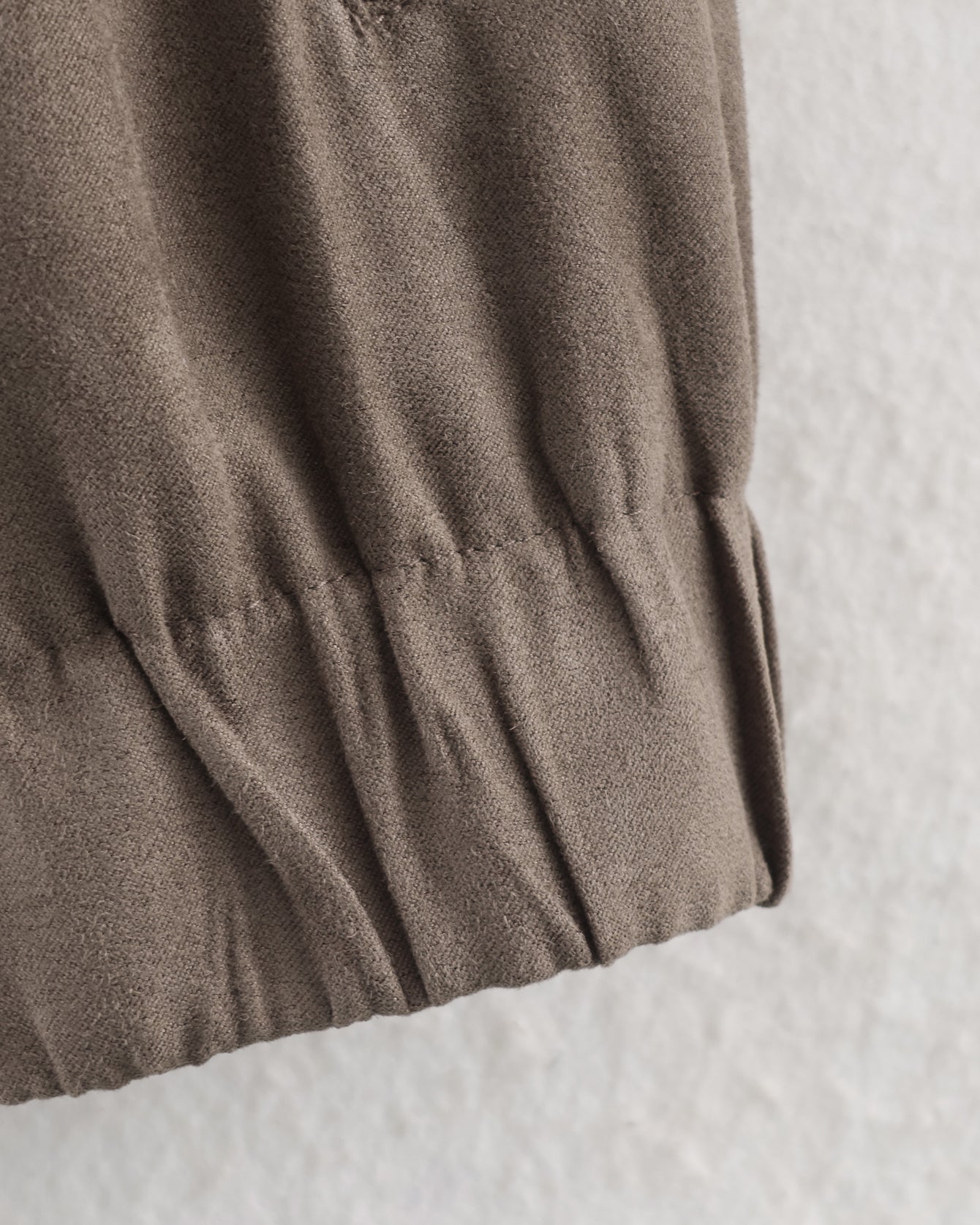 Warm cozy suede jacket in soft muted olive-green cotton fabric with wrinkled texture