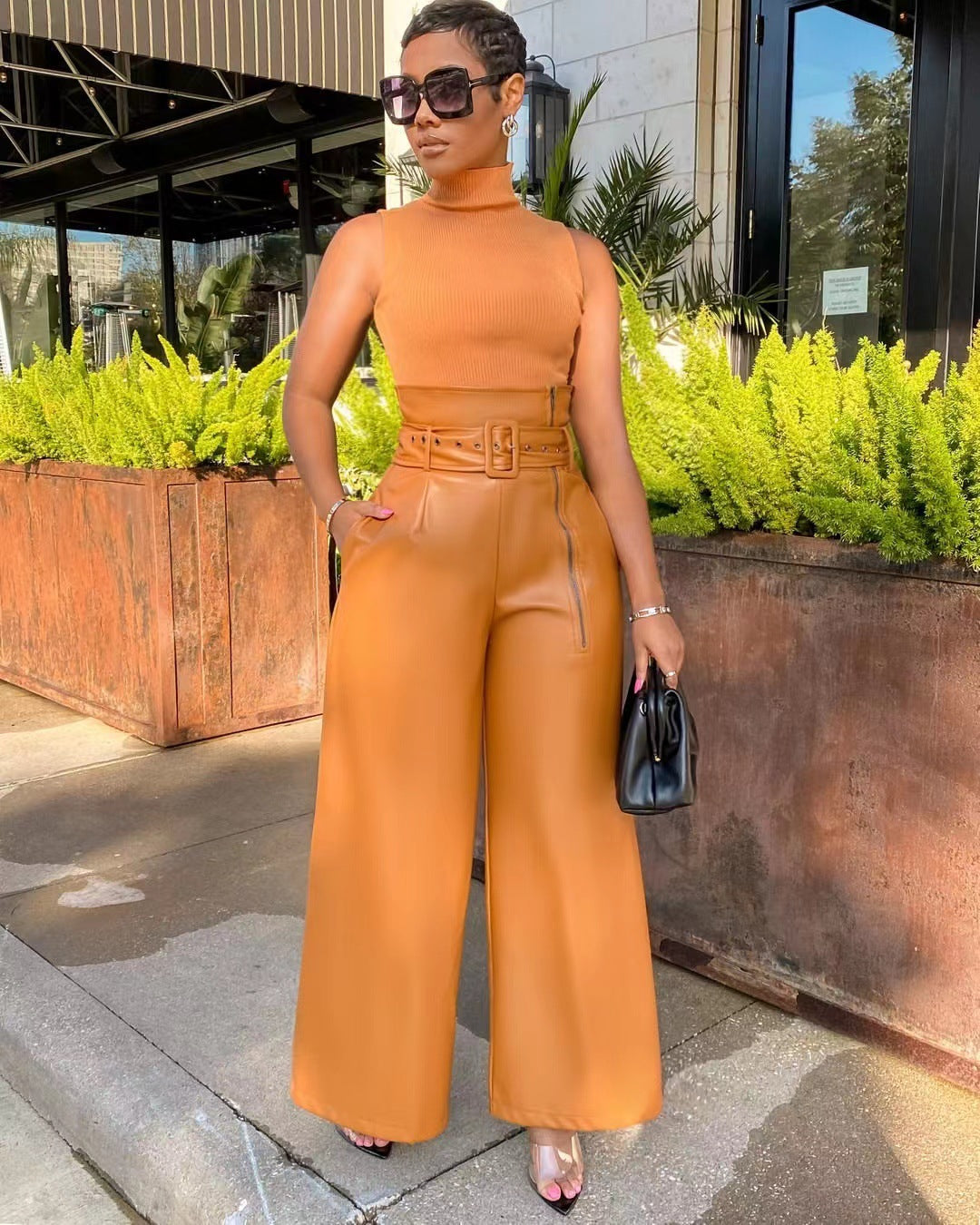Woman wearing high waist faux leather pants and matching top in tan color