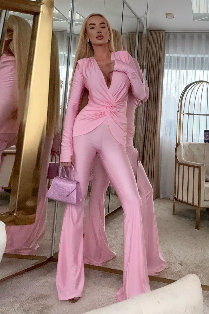 Pink satin long sleeve jumpsuit with deep V-neck and flared pants