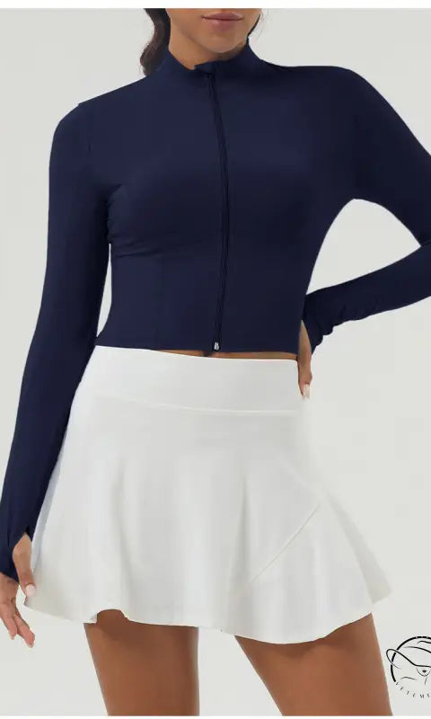 Woman in long sleeve sports jacket with zipper and white pleated skirt