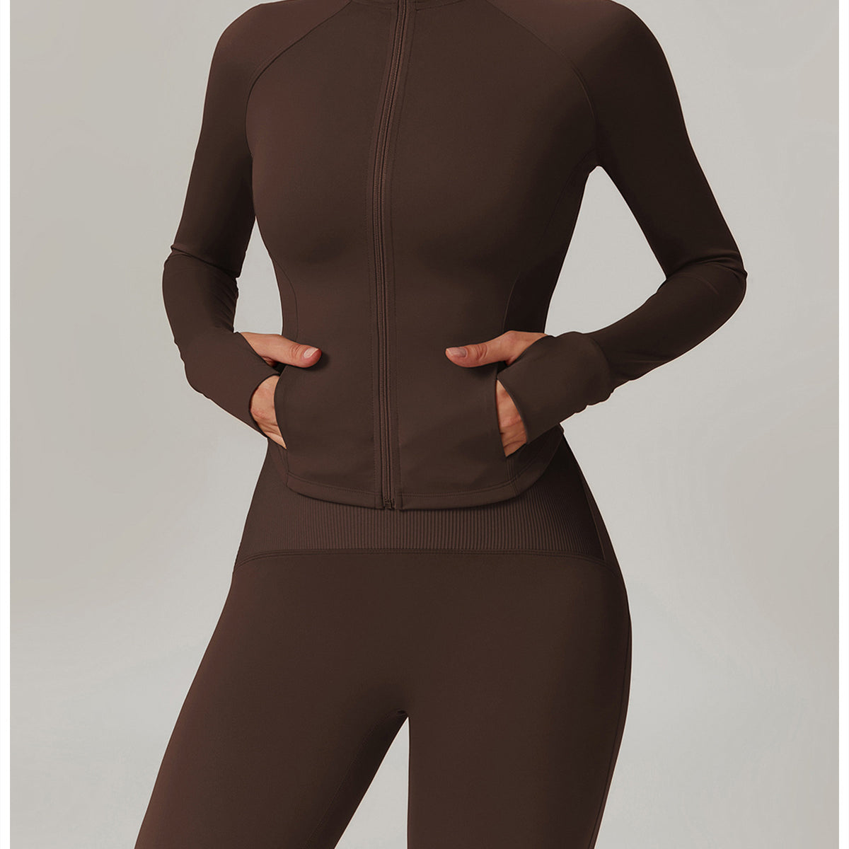 Brown athletic zip-up jumpsuit, ideal for yoga, featuring a fitted design and long sleeves